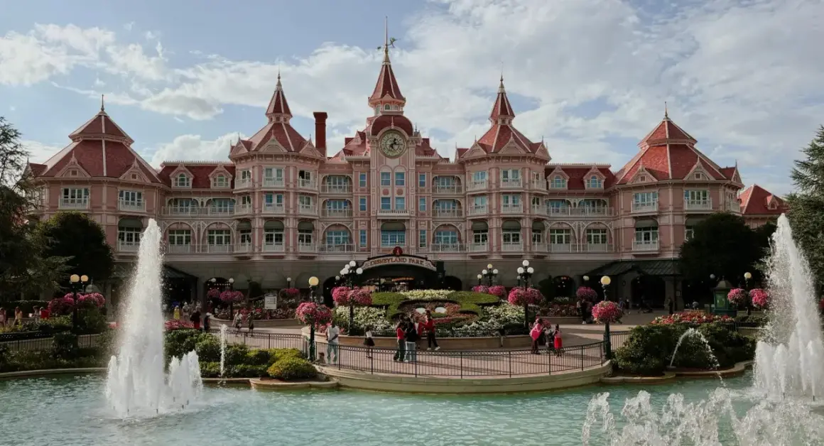 El hotel rosa de Disneyland Paris con fuentes y flores. ¡Un lugar mágico para hacer camping y disfrutar!