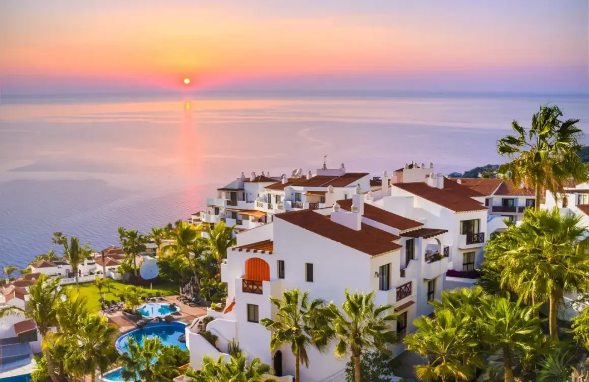 Resort con piscinas y palmeras al atardecer. Un lugar ideal para tus destinos para viajar en enero.