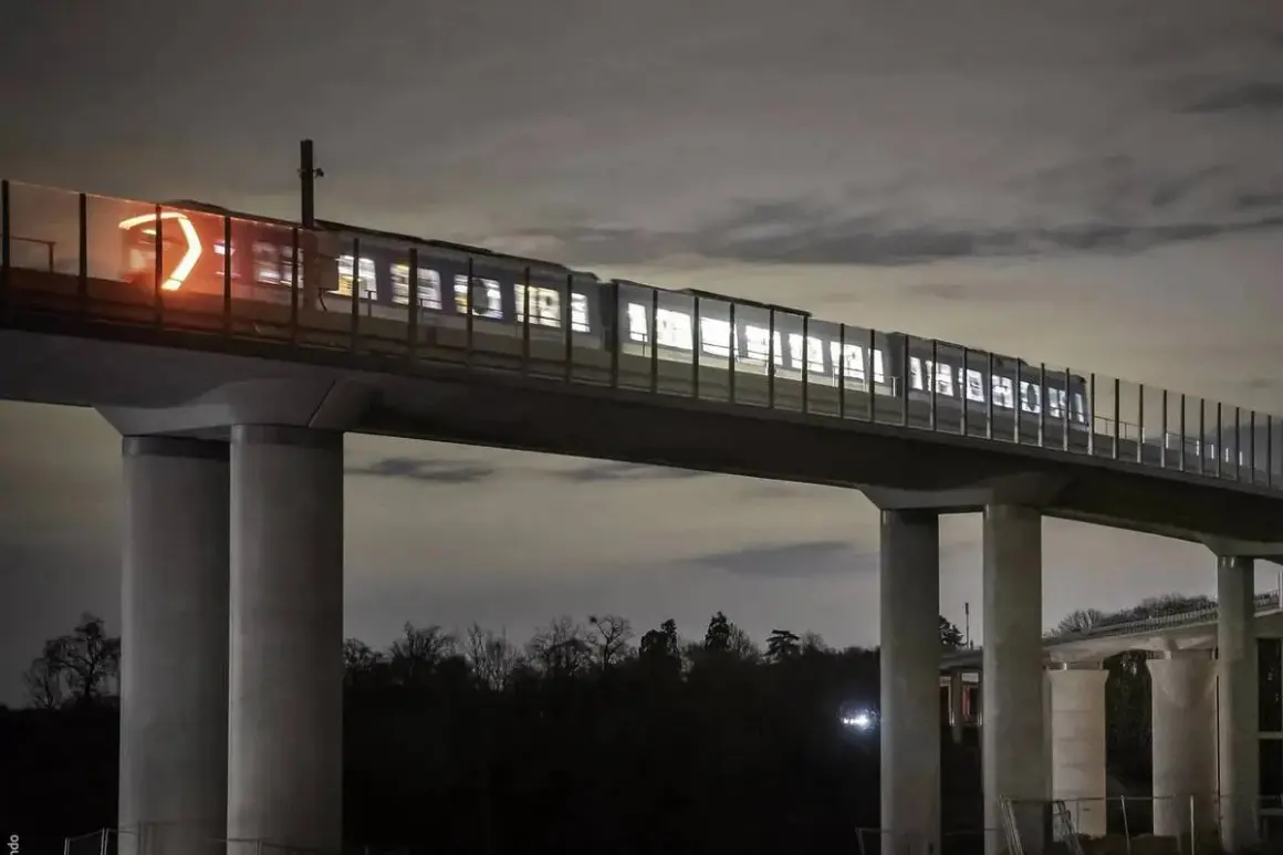 Un tren ilumina la noche sobre un viaducto, parte de las **líneas metro París**. Sus luces brillan a través de las ventanas, creando un espectáculo nocturno.