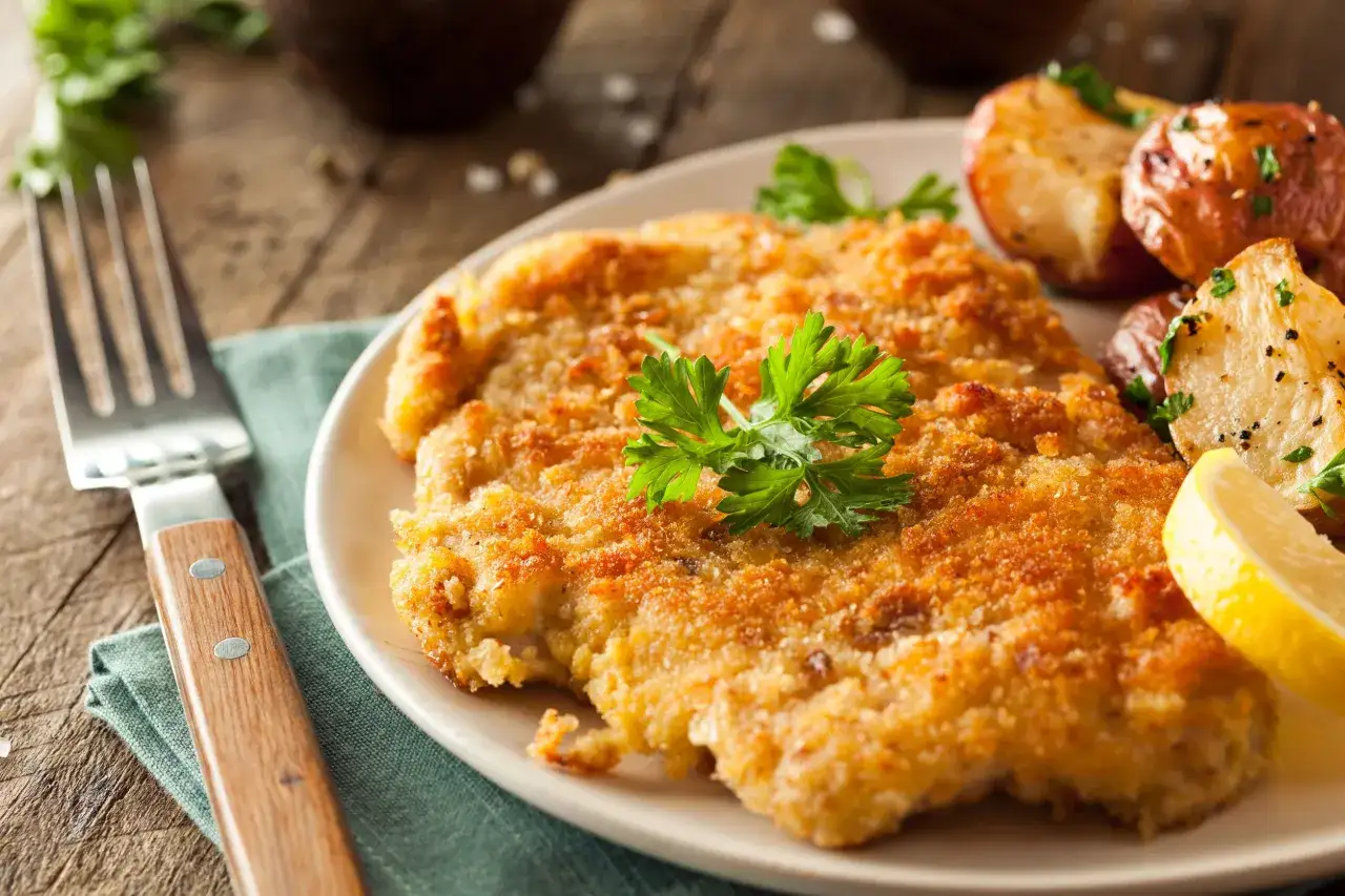 Wiener Schnitzel, un clásico que comer en Viena. Crujiente, dorado y servido con patatas asadas y limón.