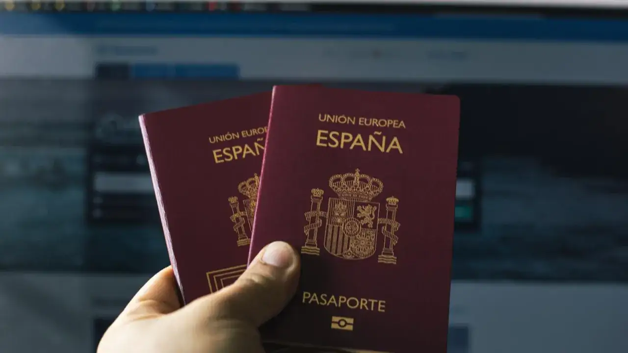 Dos pasaportes espa&ntilde;oles en mano, listos para investigar el precio visado India.
