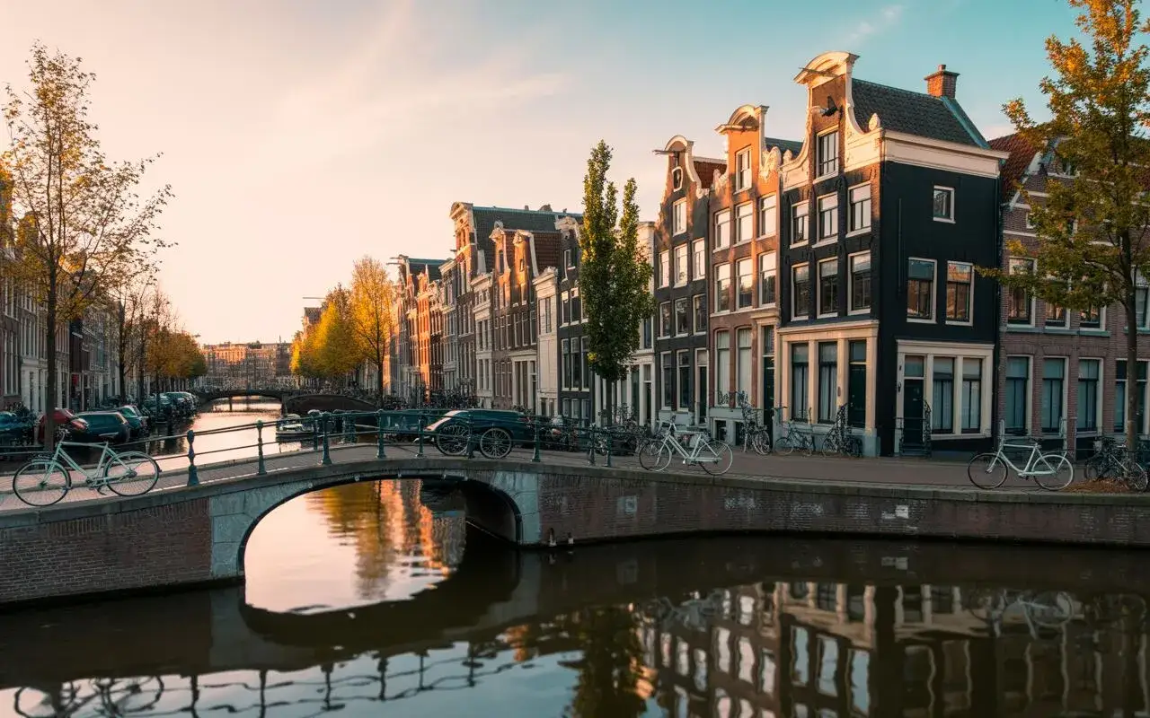 Canales y casas t&iacute;picas de &Aacute;msterdam al atardecer. Ideal para planificar qu&eacute; ver en &Aacute;msterdam en 2 d&iacute;as.