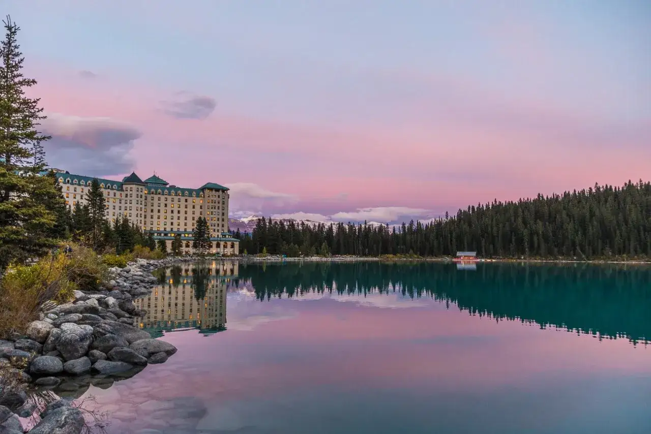 Impresionante hotel junto a un lago turquesa en Canad&aacute;, con monta&ntilde;as nevadas y un cielo rosado. Un lugar que ver para so&ntilde;ar.