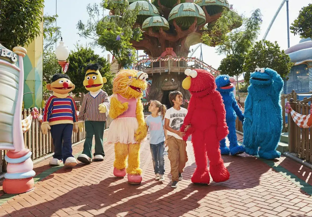 Personajes de Barrio Sésamo pasean con niños en PortAventura, creando un día mágico para los más pequeños.