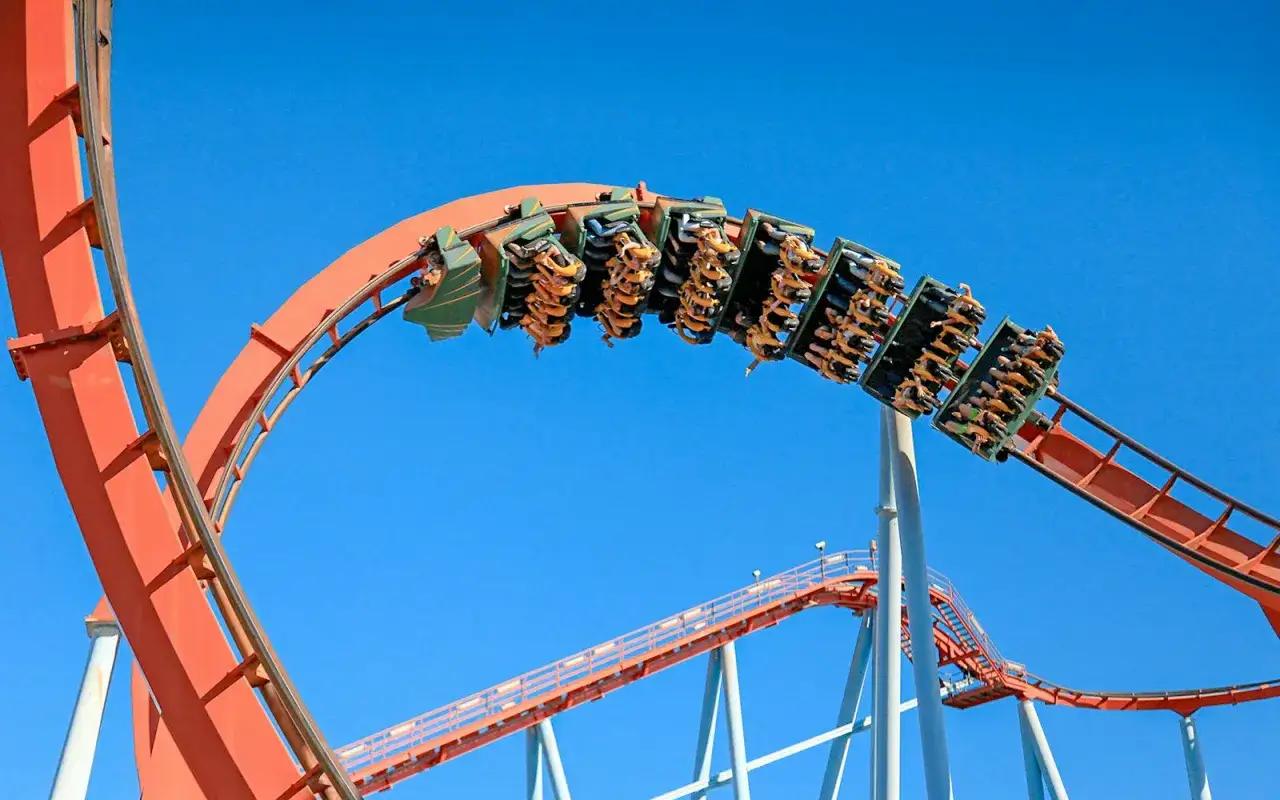 Tren de la montaña rusa con pasajeros, listo para la acción cuando abre la Warner. ¡Emoción garantizada!