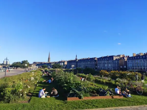 Gente relajándose en un jardín urbano con vistas a Burdeos. ¡Así se llega a la tranquilidad!