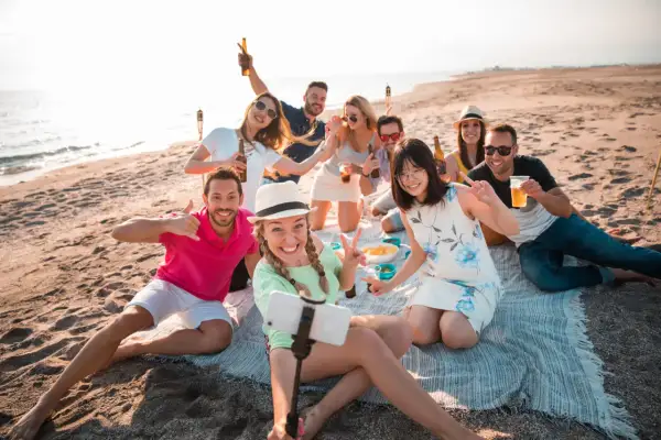 Un grupo de amigos celebra en la playa, un lugar perfecto para disfrutar del sol y la compañía.