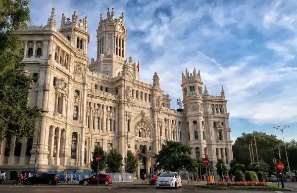 Edificio de Correos y Telégrafos, un lugar clave que ver en Madrid en un día. Fachada monumental, torre con reloj y cielo azul.