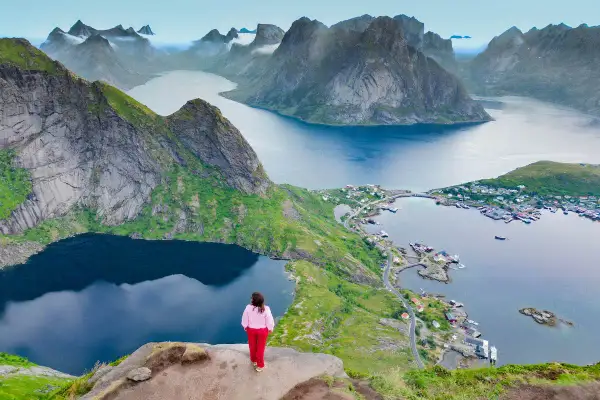 Una persona contempla las majestuosas islas Lofoten. Descubre cómo llegar a este paraíso noruego.