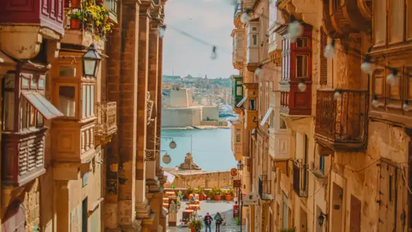 Calle estrecha con balcones de madera y vistas al mar. Ideal para escapadas fin de semana Europa.