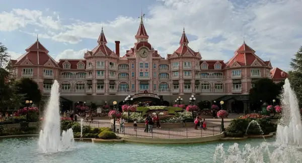 El hotel rosa de Disneyland Paris con fuentes y flores. ¡Un lugar mágico para hacer camping y disfrutar!