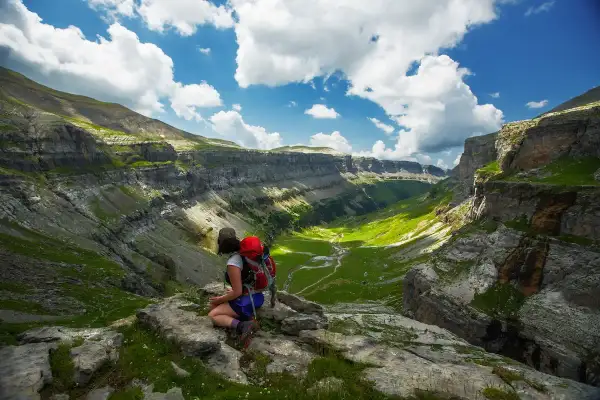 Senderista admira el valle verde de Ordesa y Monte Perdido. Un paisaje espectacular para descubrir qué ver en Ordesa y Monte Perdido.