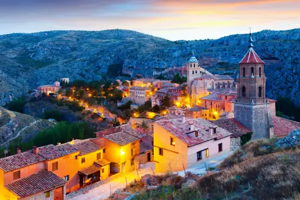Pueblo medieval iluminado al atardecer, ideal para descubrir sitios para visitar en España un fin de semana.