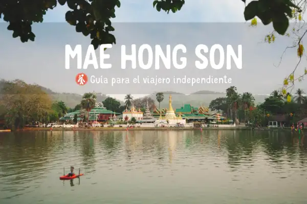 Paisaje sereno en Mae Hong Son con templos tailandeses y un pequeño bote en el lago.